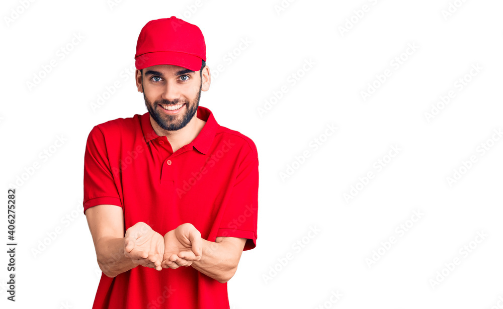 Young handsome man with beard wearing delivery uniform smiling with hands palms together receiving or giving gesture. hold and protection Young handsome man with beard wearing delivery uniform smiling with hands palms together receiving or giving gesture. hold and protection