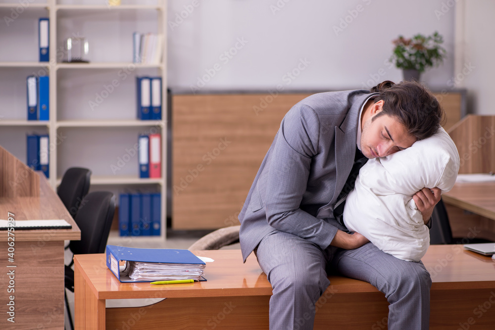 Young male employee sleeping at workplace Young male employee sleeping at workplace