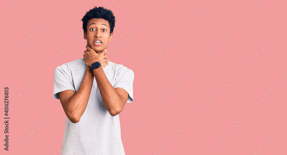 Young african american man wearing casual clothes shouting and suffocate because painful strangle. health problem. asphyxiate and suicide concept. Young african american man wearing casual clothes shouting and suffocate because painful strangle. health problem. asphyxiate and suicide concept.