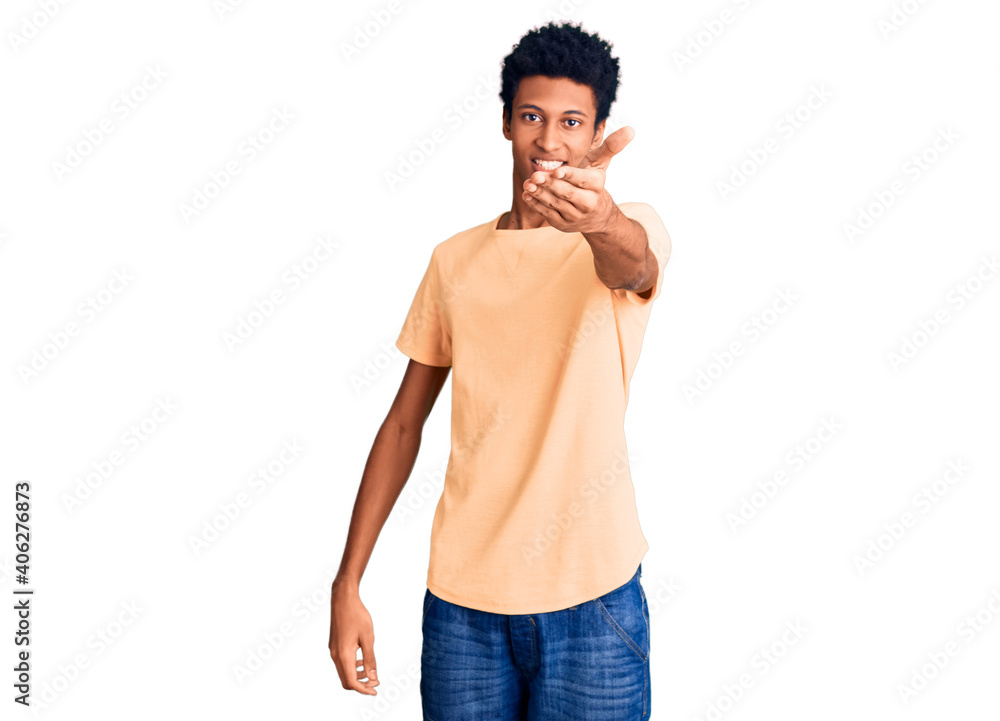 Young african american man wearing casual clothes smiling friendly offering handshake as greeting and welcoming. successful business. Young african american man wearing casual clothes smiling friendly offering handshake as greeting and welcoming. successful business.