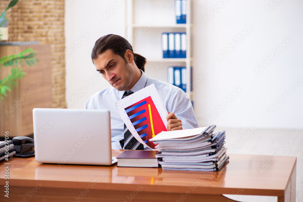 Young male sales analyst preparing financial report Young male sales analyst preparing financial report