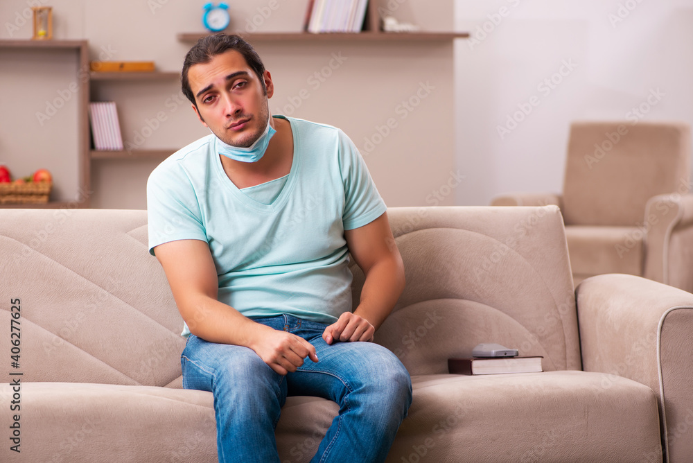 Obraz premium Young man sitting at home during pandemic