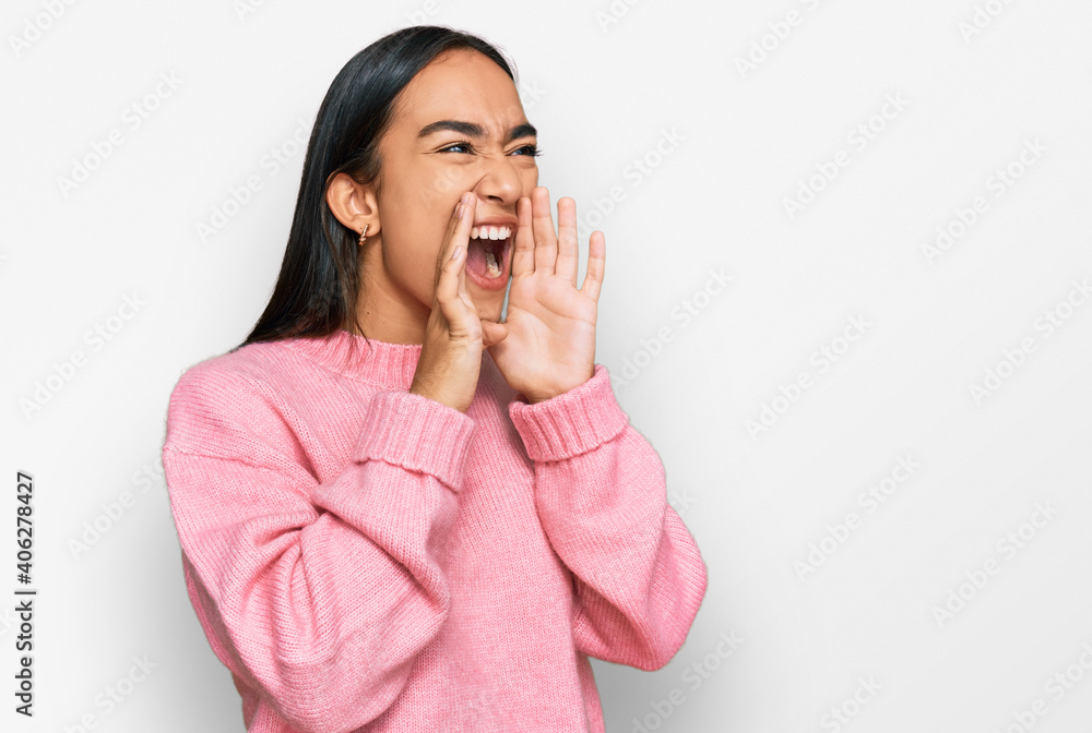 Young asian woman wearing casual winter sweater shouting angry out loud with hands over mouth Young asian woman wearing casual winter sweater shouting angry out loud with hands over mouth