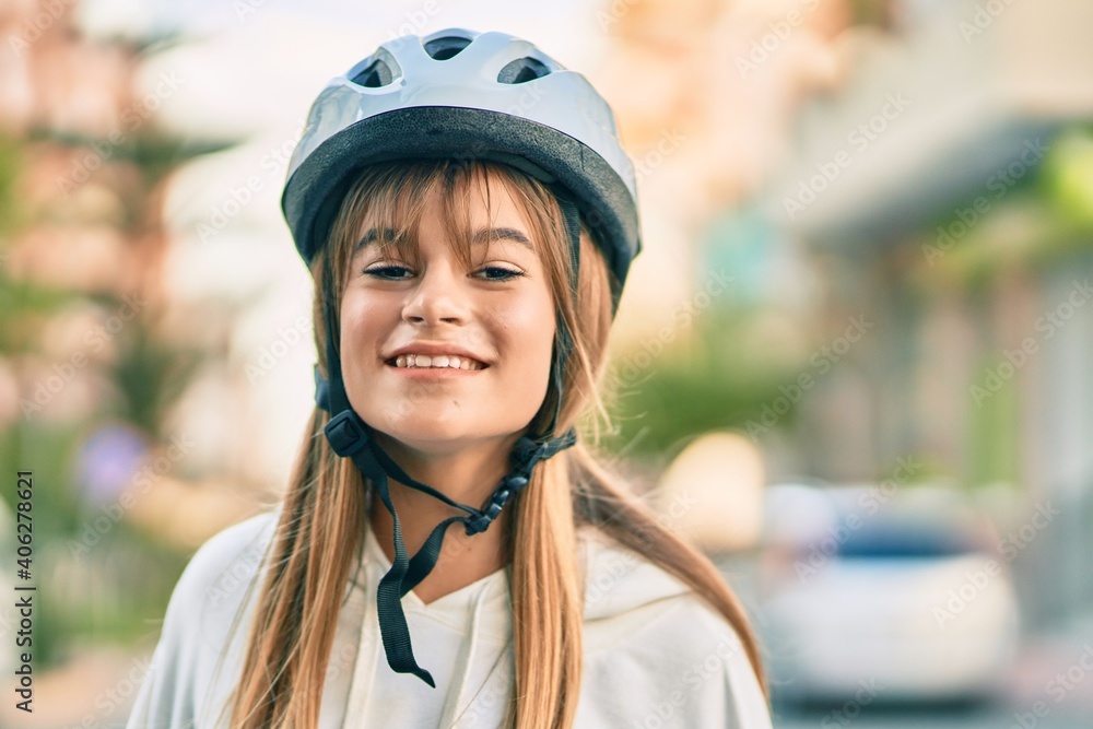 Caucasian sporty teenager girl smiling happy wearing bike helmet at the city. Caucasian sporty teenager girl smiling happy wearing bike helmet at the city.