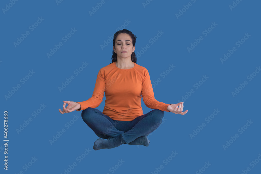 Brunette woman levitating and doing yoga, on a blue background Brunette woman levitating and doing yoga, on a blue background