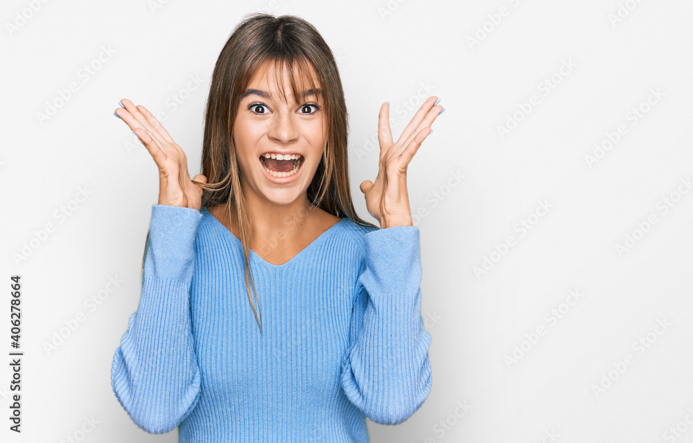 Teenager caucasian girl wearing casual clothes celebrating crazy and amazed for success with arms raised and open eyes screaming excited. winner concept Teenager caucasian girl wearing casual clothes celebrating crazy and amazed for success with arms raised and open eyes screaming excited. winner concept