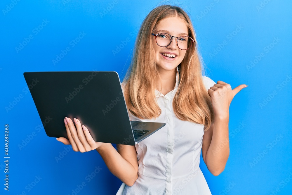 Beautiful young caucasian girl working using computer laptop pointing thumb up to the side smiling happy with open mouth Beautiful young caucasian girl working using computer laptop pointing thumb up to the side smiling happy with open mouth