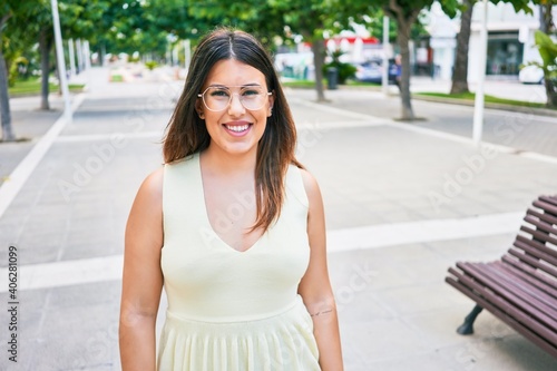 Young beautiful woman smiling happy. Standing with smile on face looking at the camera walking at town street.