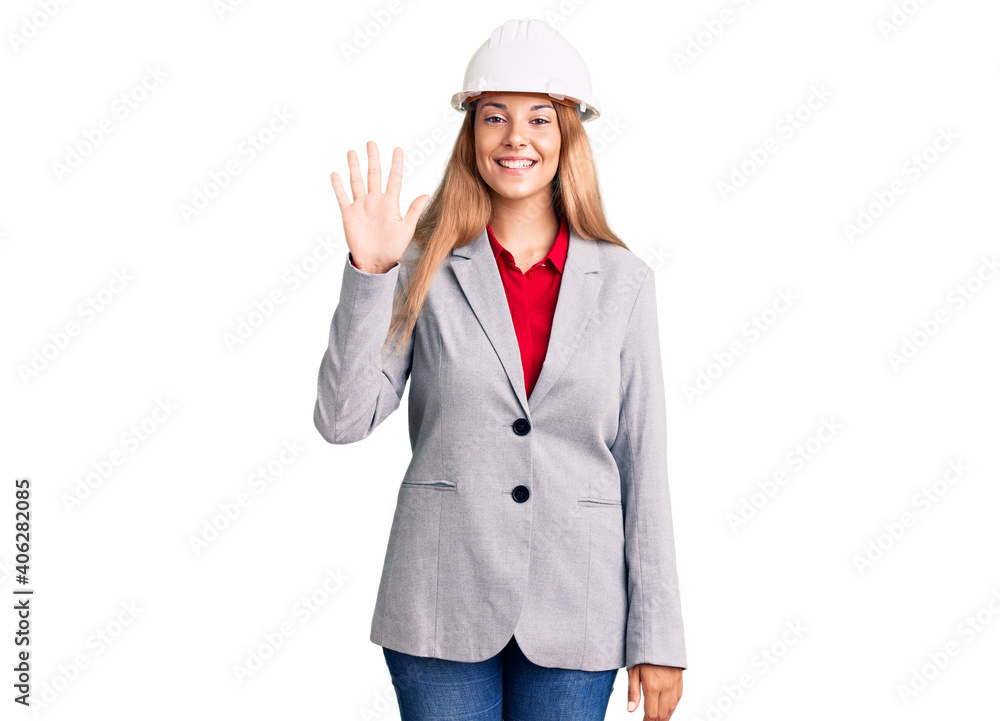 Beautiful young woman wearing architect hardhat showing and pointing up with fingers number five while smiling confident and happy. Beautiful young woman wearing architect hardhat showing and pointing up with fingers number five while smiling confident and happy.