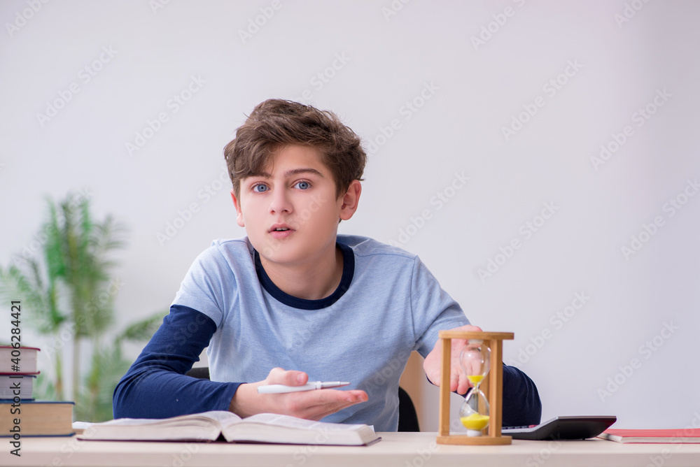 Schoolboy preparing for exams in time management concept Schoolboy preparing for exams in time management concept
