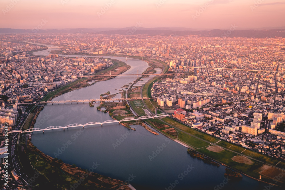 Panoramic view of sunset over Osaka cityscape and Yodo River, Japan