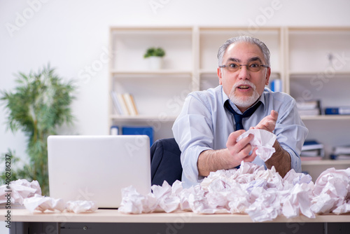 Old businessman rejecting new ideas with lots of papers
