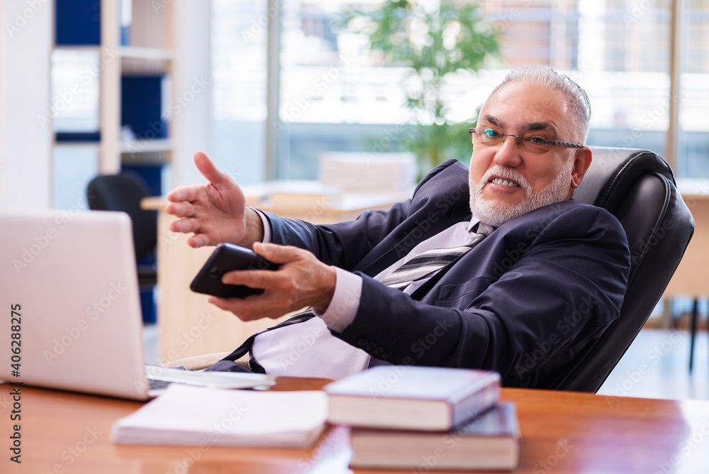 Old businessman employee working in the office Old businessman employee working in the office