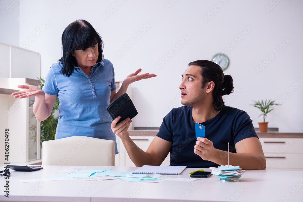 Female pensioner and her young son in budget planning concept Female pensioner and her young son in budget planning concept