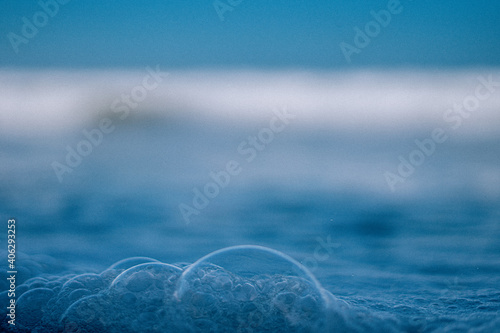 Blue bubbles from wave foam in the sea