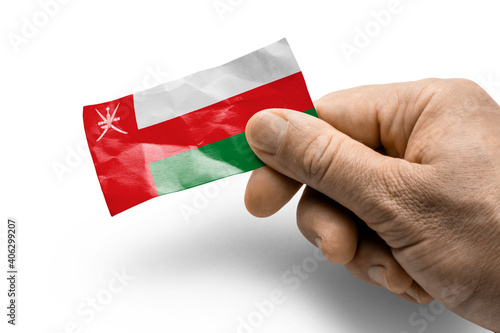 Hand holding a card with a national flag the Oman