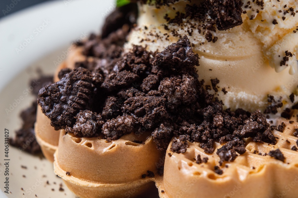 Chocolate waffles with chocolate biscuit slices sprinkled and given vanilla ice cream
