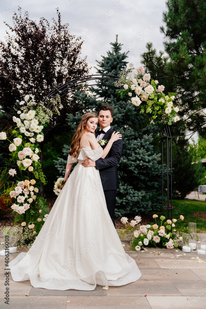 outdoor wedding ceremony in an arch of living flowers.Beautiful couple newlyweds