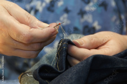 woman removing basting from sewn trousers