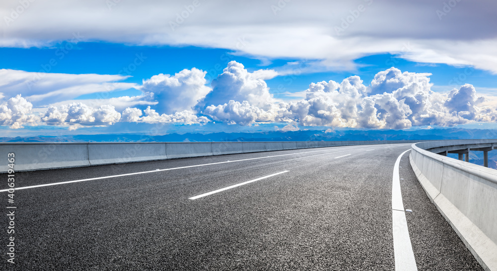 Fototapeta premium Empty asphalt road and blue sky with white clouds.Road background.