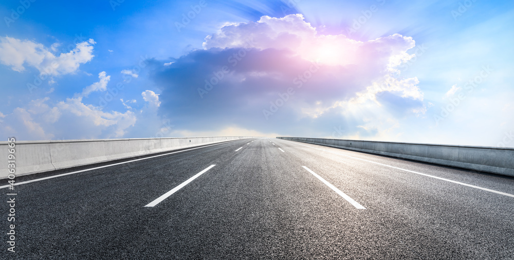 Fototapeta premium Empty asphalt road and blue sky with white clouds.Road background.