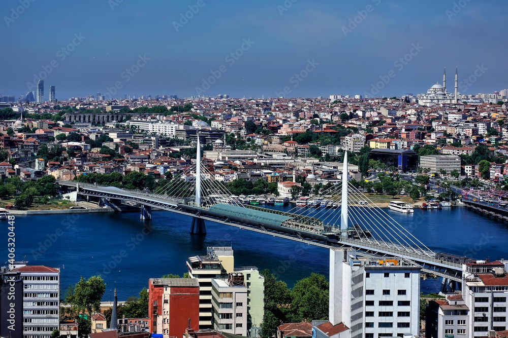 Panorama of Istanbul from above. In the foreground is the bridge over the Bosphorus. There are many old and modern city buildings in the distance. Summer sunny day. Turkey