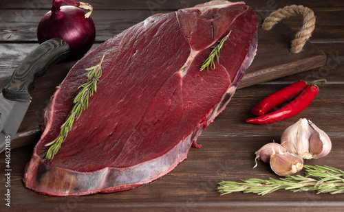 piece of fresh raw meat on a wooden background. meat and spices. Moose meat is considered one of the most low-calorie and useful for the human body.