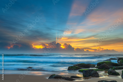 High cloud seascape with sun rays starting to show through the cloud bank on the horizon photo