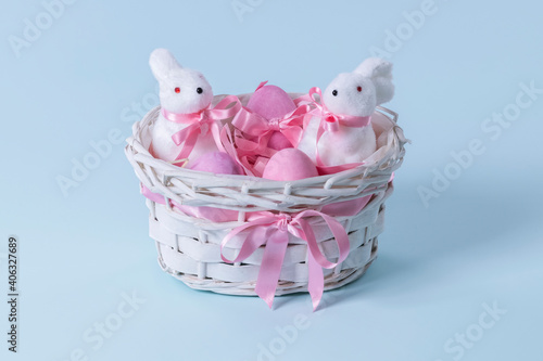 eater eggs with bunny figurines in a wicker basket