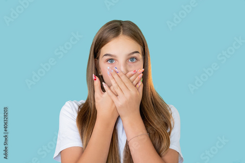 Shocked girl. Unexpected news. Omg really. Special offer. Portrait of surprised overwhelmed young lady with colorful manicure covering mouth with hands isolated on blue copy space background.