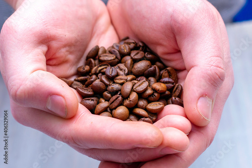 whole coffee beans in the palms of a person