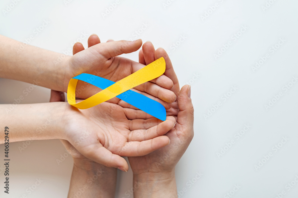 Blue yellow awareness ribbon on helping hand for World down syndrome ...