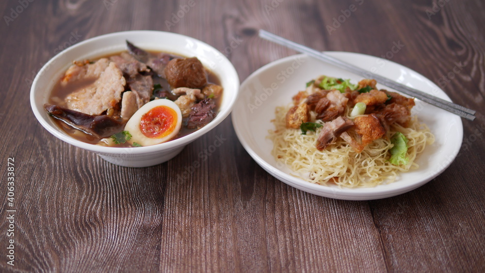 Set of Chinese noodle, a bowl of paste of rice flour over with pork egg and a plate of egg noodle with crispy pork Set of Chinese noodle, a bowl of paste of rice flour over with pork egg and a plate of egg noodle with crispy pork