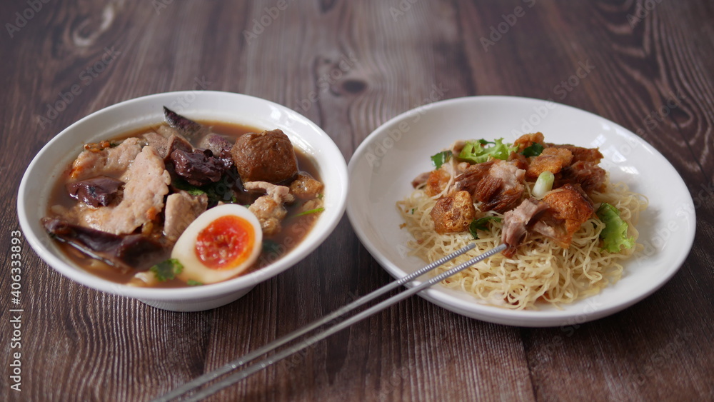 Set of Chinese noodle, a bowl of paste of rice flour over with pork egg and a plate of egg noodle with crispy pork Set of Chinese noodle, a bowl of paste of rice flour over with pork egg and a plate of egg noodle with crispy pork