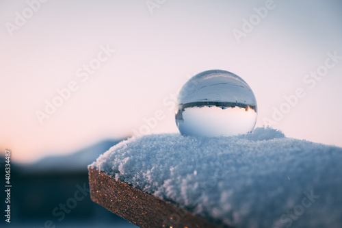 glass transparent ball in the snow in winter, sun rays reflection. severe frost, cold © Alexandr Pobeda