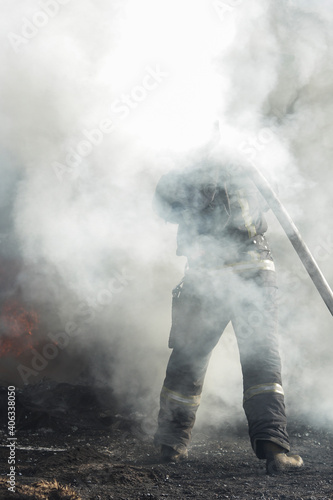 Firefighters extinguish a fire. Lifeguards with fire hoses in smoke and fire