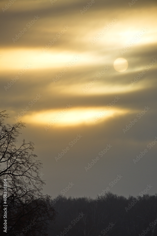 Obraz premium Cold sun in the winter cloudy sky.