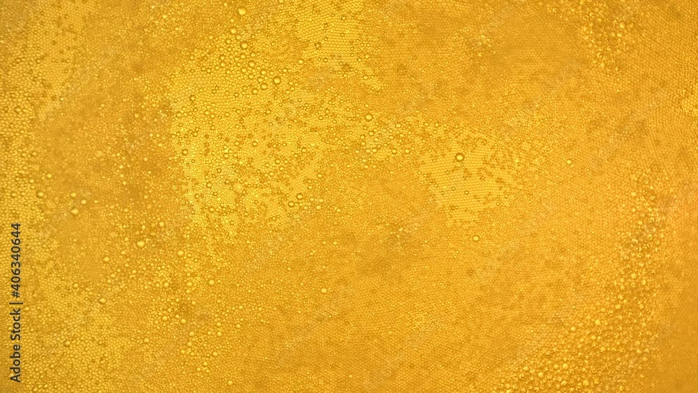 Slow motion shooting of bubbles in a glass of beer. The view from the top of a Golden background. Slow motion shooting of bubbles in a glass of beer. The view from the top of a Golden background.