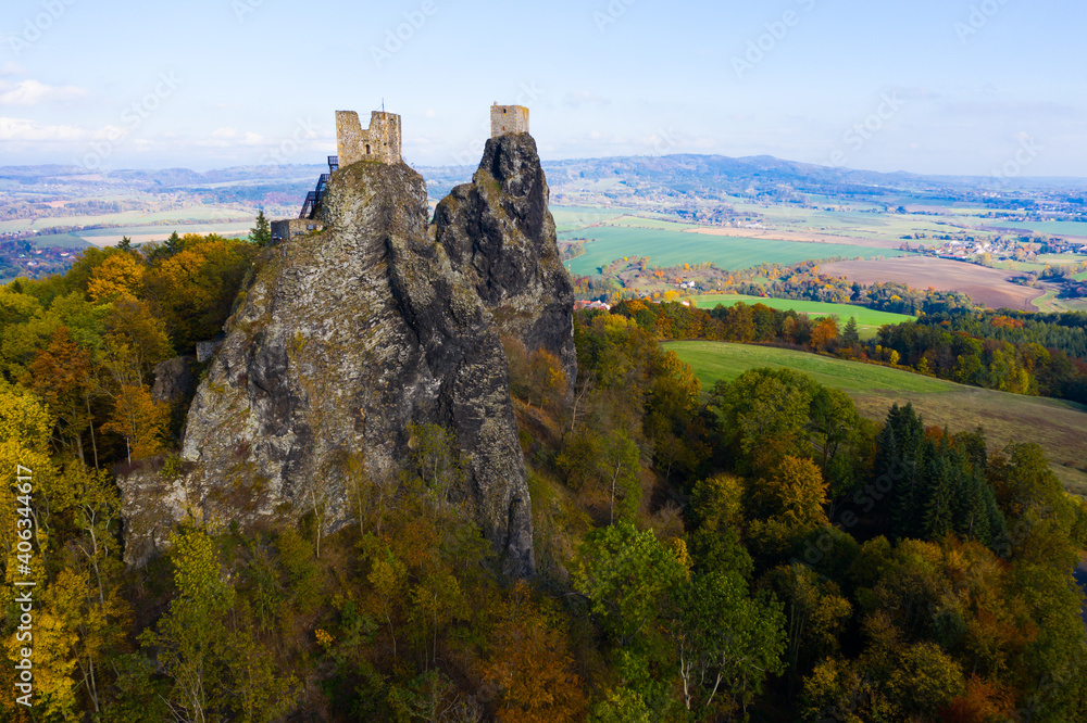 Aerial view of two towers of ruined abandoned Trosky Castle on tops of stone rocks domineering over Czech nature reserve of Bohemian Paradise in autumn..