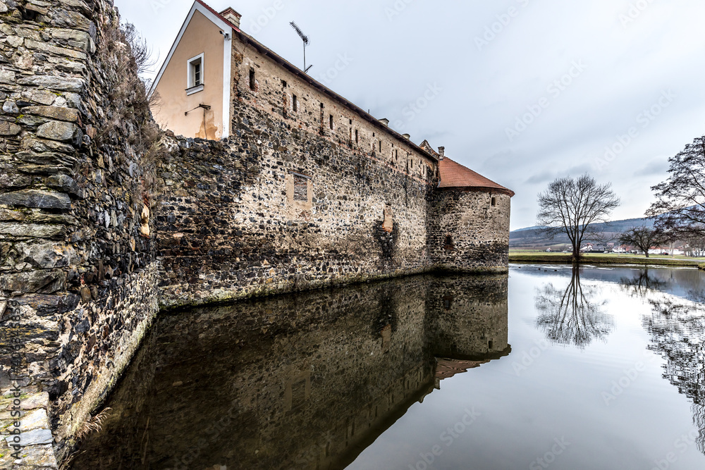 Fototapeta premium Massive and well fortified medieval Water Castle of Svihov is situated in the Pilsen Region, Czech Republic, Europe. There are water canal around the stone castle. Winter view.