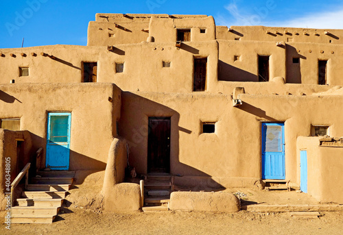 Closeup of aged buildings in Taos Pueblo under the sunlight and a blue sky in New photo