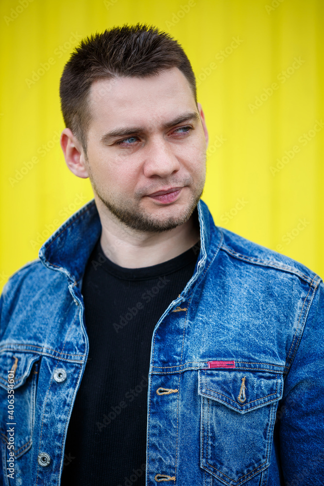 Portrait of a handsome stylish guy, a man dressed in a black blank t-shirt standing on a yellow wall background. Urban style of clothes, modern fashionable image. Men's fashion Portrait of a handsome stylish guy, a man dressed in a black blank t-shirt standing on a yellow wall background. Urban style of clothes, modern fashionable image. Men's fashion