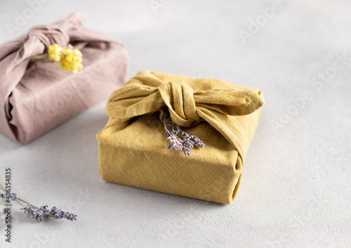 reusable sustainable gift wrapping in linen fabric. Furoshiki gifts. zero waste concept. close-up. selective focus photo