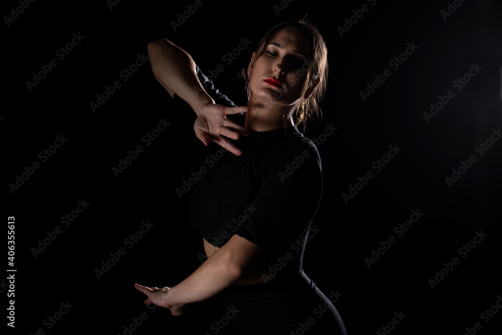 Fototapeta premium Young Woman in a black dress dancing, Young professional dancer practicing in a studio , dancer