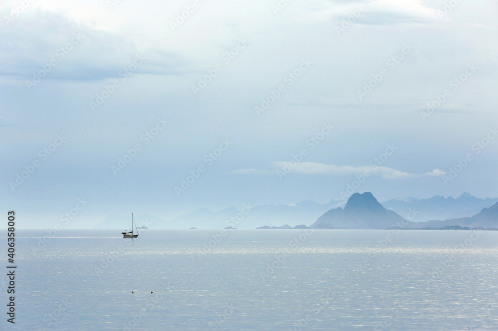 View of Ocean and Mountains, with Sailboat on the Water. Lofoten, Norway