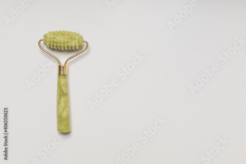 Jade roller facial massager on white background