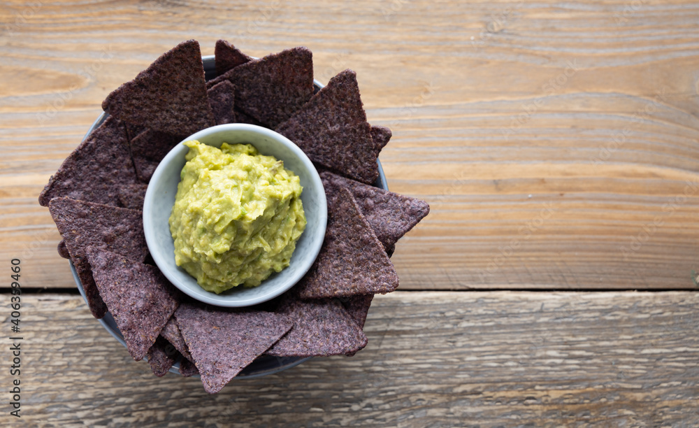 Blue corn tortilla chips with homemade guacamole on the side.