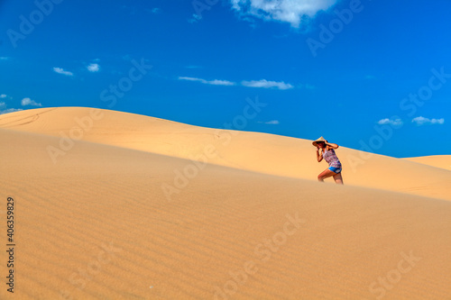 beautiful girl in the desert runs barefoot on the top of the hill in the sand