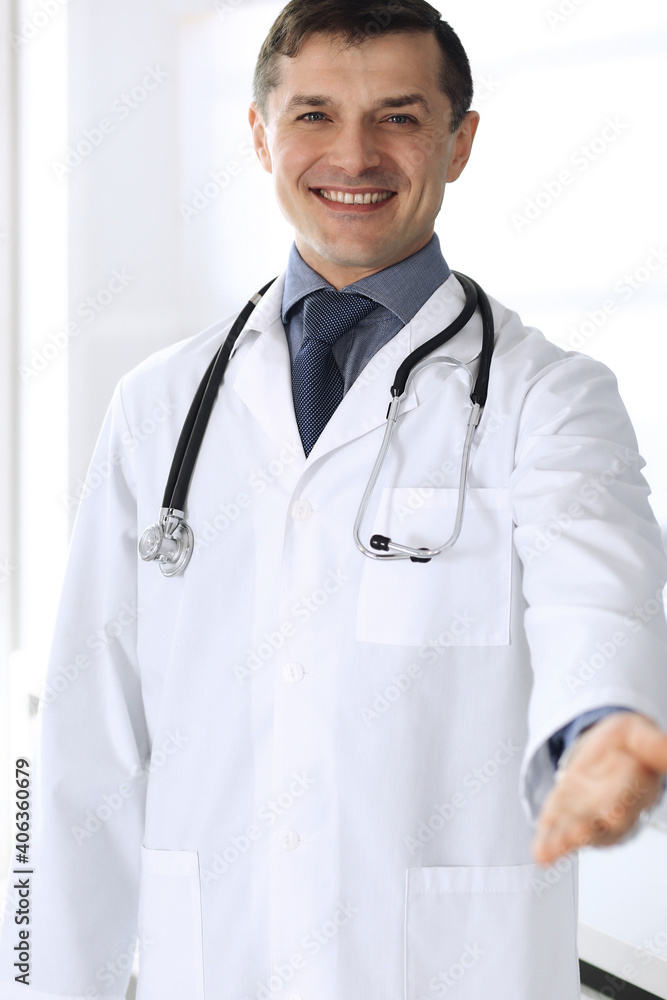 Doctor man cheerful smiling at camera, helping hand. Perfect medical service in clinic. Happy future in medicine and healthcare Doctor man cheerful smiling at camera, helping hand. Perfect medical service in clinic. Happy future in medicine and healthcare