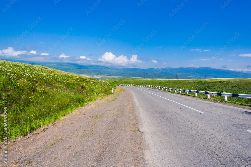 road in the middle of blooming green meadows in Armenia road in the middle of blooming green meadows in Armenia